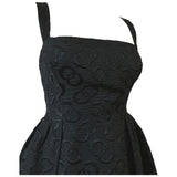 Sultry black late 1950s cocktail dress with interconnecting rings pattern