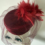 Claret satin vintage pillbox hat with mesh veil and feather trim