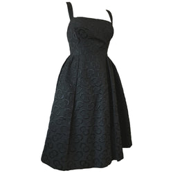 Sultry black late 1950s cocktail dress with interconnecting rings pattern